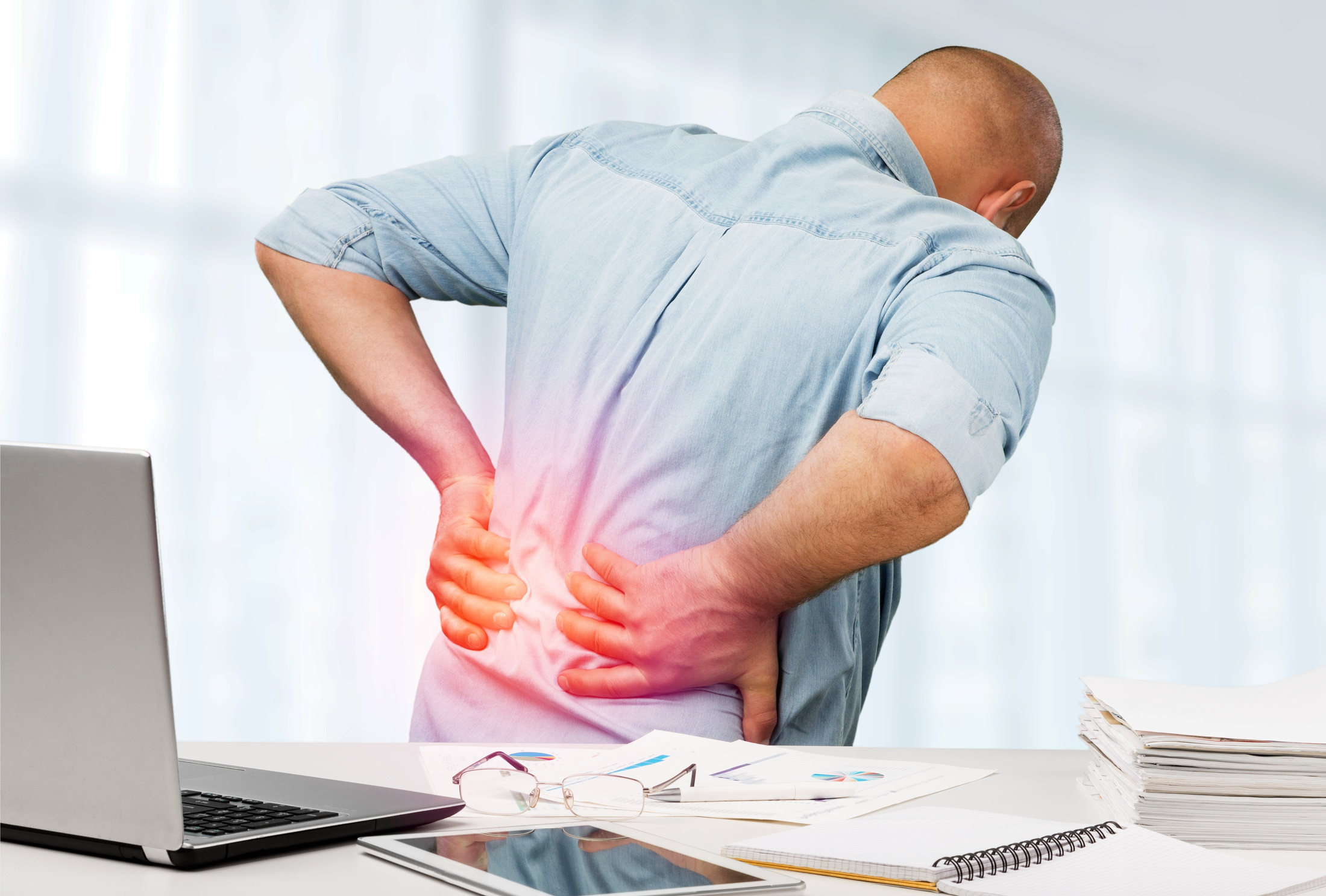 Business Man with Back Pain an Office . Pain Relief Concept