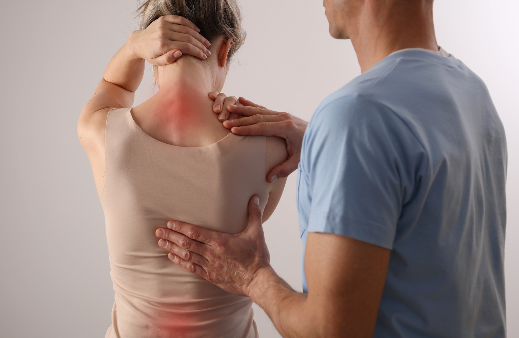 Woman with back pain. Spine physical therapist and patient. Chiropractic pain relief therapy.